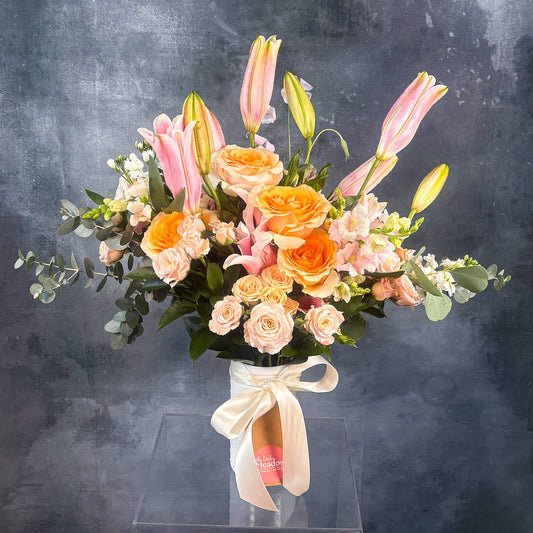 Bouquet of flowers with pink, orange, and green colors on a dark background