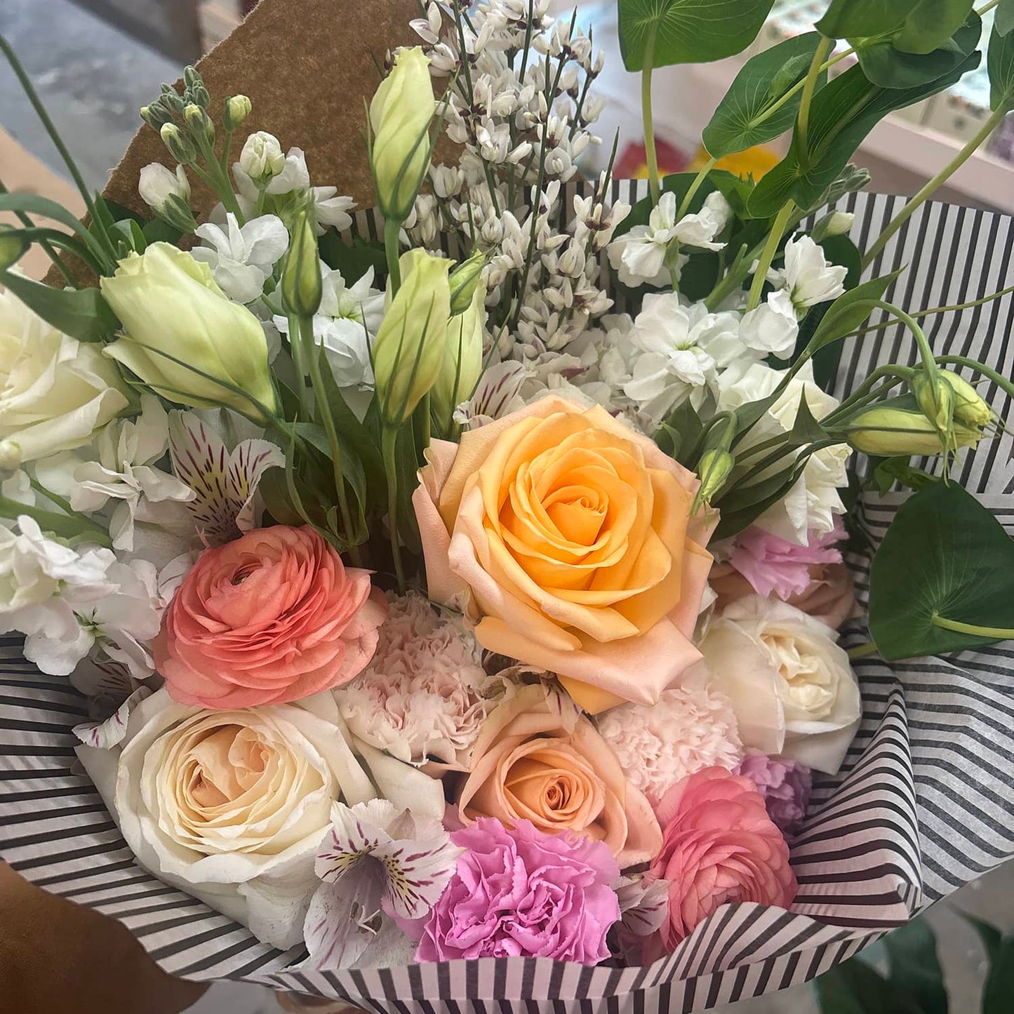 Bouquet of flowers with a striped box in a store setting