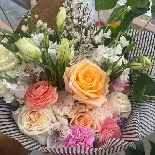 Bouquet of flowers with a striped box in a store setting